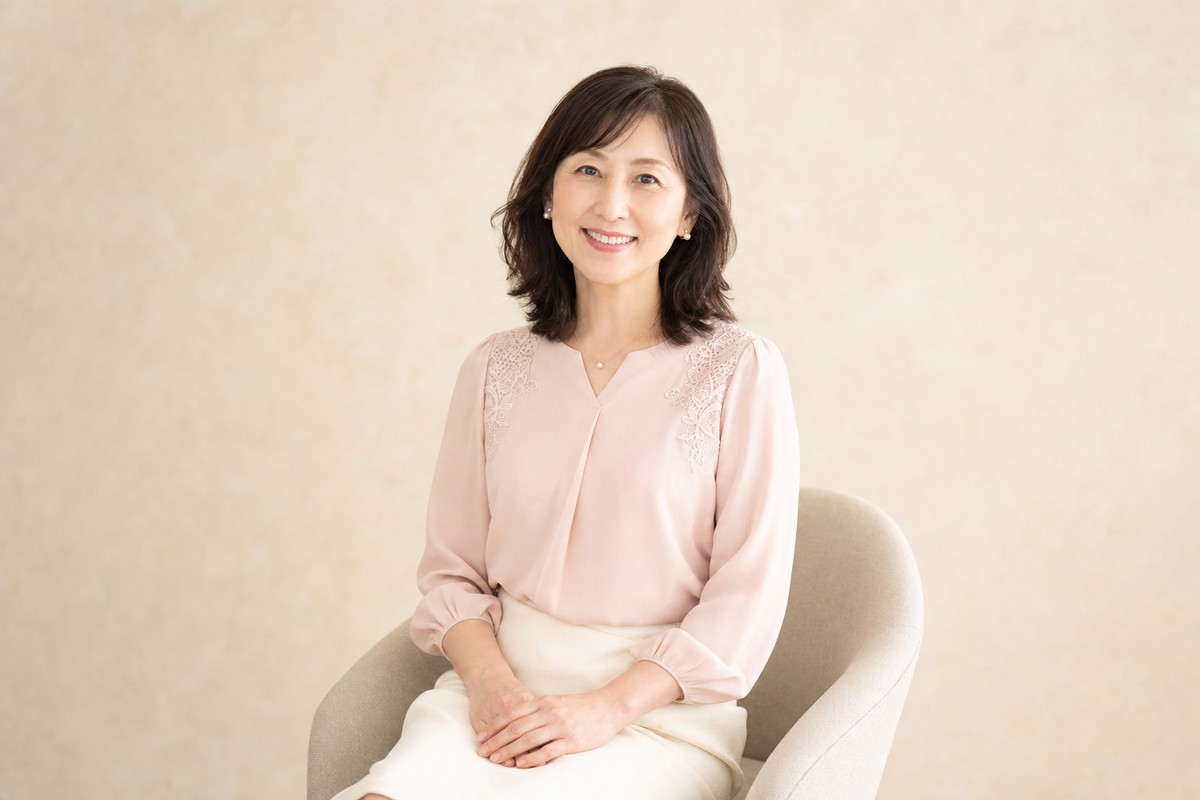 淡いピンクのブラウスを着た婚活プロフィール写真向けコーデ